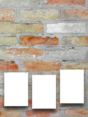 Close-up of three paper sheet frames hung by clothes pin on brick wall background