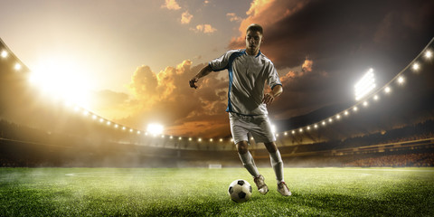 Fototapeta na wymiar Soccer player in action on sunset stadium panorama background
