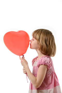 Little girl in pink dress holding a balloon