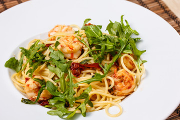 Pasta with shrimp and arugula.