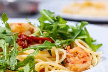 Pasta with shrimp and arugula.