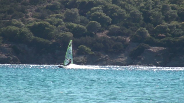 A windsurfer in the sea during the summer period.