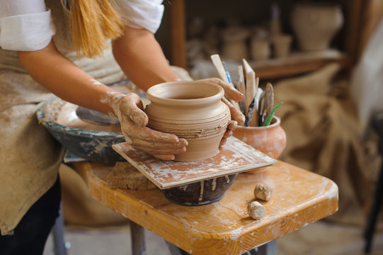hands of a potter, creating an earthen jar on the circle