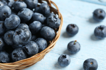 Blueberries in basket on a blue wooden background