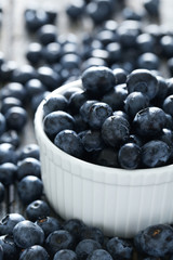 Blueberries in bowl on a blue wooden background
