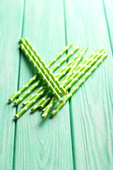 Drink straws on a mint wooden background