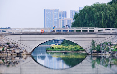 Bridge reflected in a lake at twilight, Niantan Park, Daxing dictrict, Beijing, China