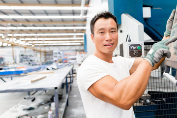 Asian worker in production plant on the factory floor