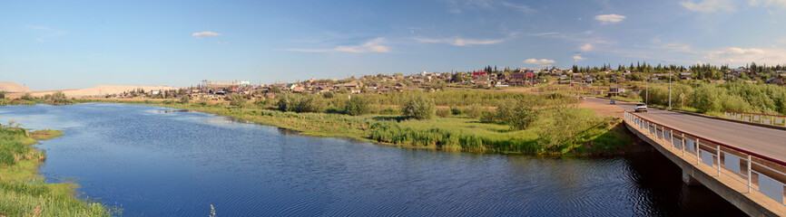 Fototapeta na wymiar Rural area in the town of Mirny, Irelyakh bridge over the river.