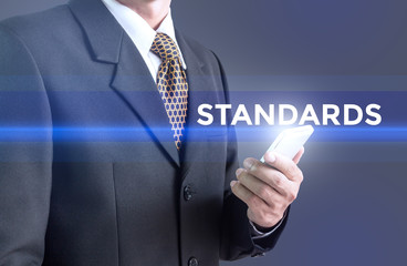 A Businessman holding a white sign with the message standards. Can bring to the medium of your ad.