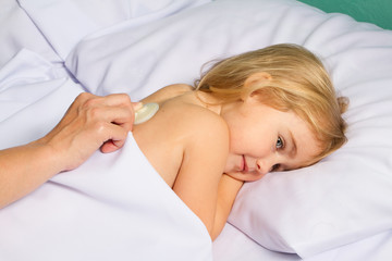 Obraz na płótnie Canvas Pediatric doctor examine little girl with stethoscope