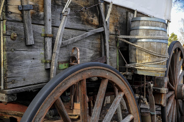 Side  view of pioneer wagon with wheel and water barrel  - obrazy, fototapety, plakaty