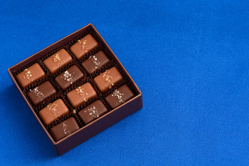 Special occasion box of salted caramel chocolates on a blue background
