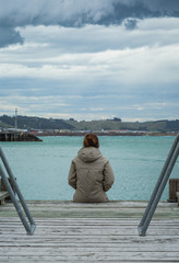 woman sit at the edge of the bridge