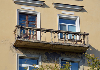 Fototapeta na wymiar Разрушающийся балкон на стене старого здания