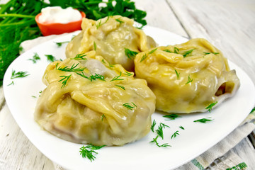 Manty with dill in dish on board