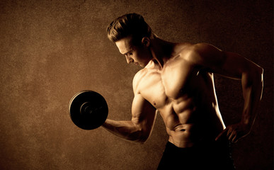 Muscular fit bodybuilder athlete lifting weight