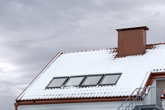 skylight and red chimney on snow covered roof