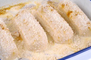 Plat de quenelles avec de la sauce blanche avant la cuisson