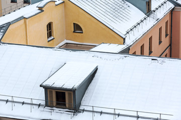 snowy roof of residential houses with gable dormers