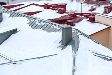 top view on snowy metal roofs of residential houses