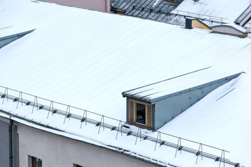 snowy roof of residential houses with gable dormers