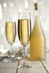 Happy new year - glasses of champagne and bottle on shining back