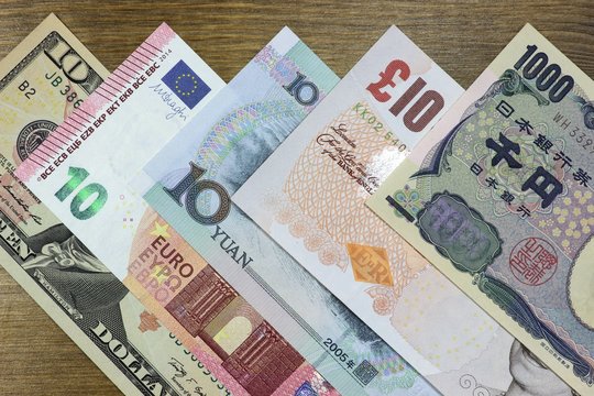 Banknoten gro&szlig;er Volkswirtschaften auf Holzhintergrund