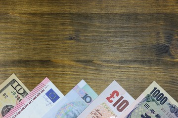 Banknoten großer Volkswirtschaften auf Holzhintergrund