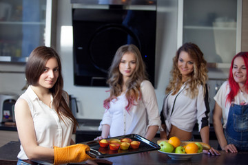 girl with baked cupcakes in her kitchen,  beautiful young woman gets out of  oven muffins