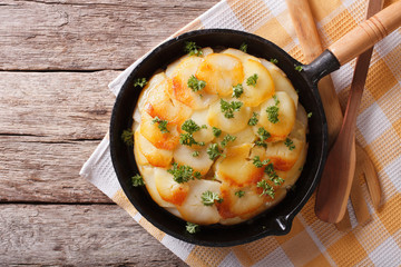 Potato gratin in a pan close-up. Horizontal top view
