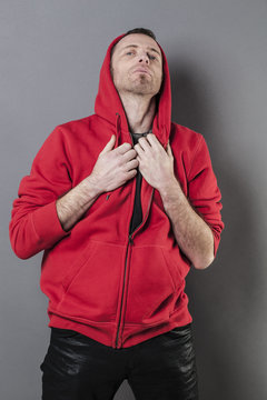 pride and arrogance - outraged 40s man wearing a red hoodie acting offended for confrontation and attitude,gray background in studio
