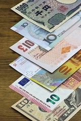 Banknoten großer Volkswirtschaften auf Holzhintergrund