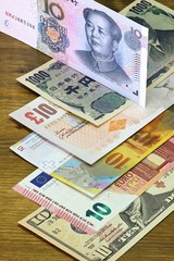 Banknoten großer Volkswirtschaften auf Holzhintergrund
