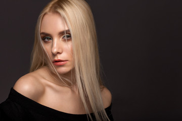 Portrait of blonde girl on a gray background