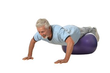 Senior man exercising with fitness ball