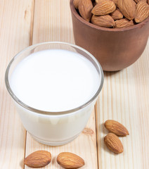 Almond milk with almond on a wooden table.