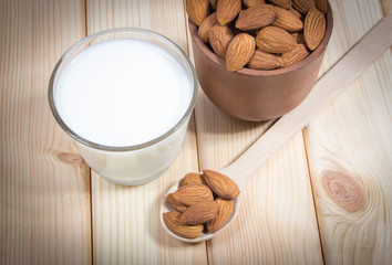 Almond milk with almond on a wooden table.