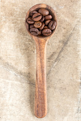 Spoon with roasted coffee beans.