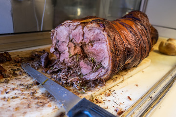 

Porchetta sul tagliere pronta per essere affettata e consumata
