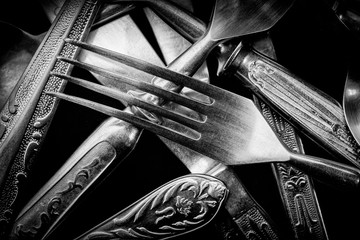Abstract black and white photo of mixed silver forks, spoons and