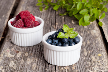Blueberries and raspberries bowl on wooden table