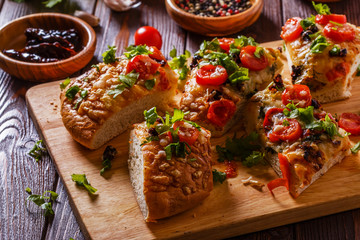 Homemade focaccia with tomatoes, sun-dried tomatoes, mozzarella