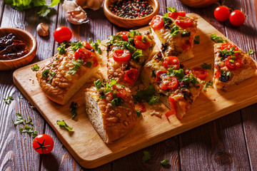 Homemade focaccia with tomatoes, sun-dried tomatoes, mozzarella