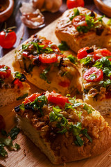 Homemade focaccia with tomatoes, sun-dried tomatoes, mozzarella