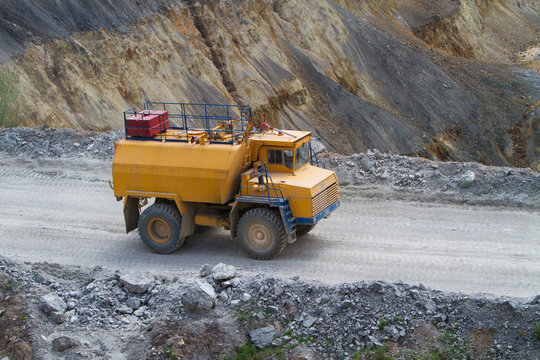 Yellow truck with water cannon on coper surface mining