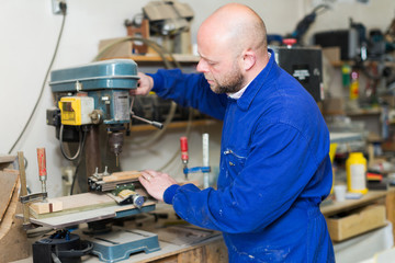 Man working on a machine at guitar workshop
