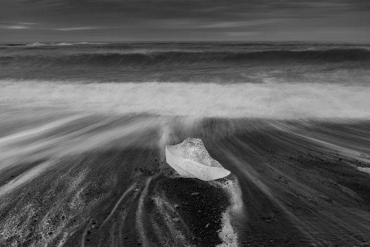 Fototapeta Ice cube with smooth wave at black sand beach Iceland black ans white tone