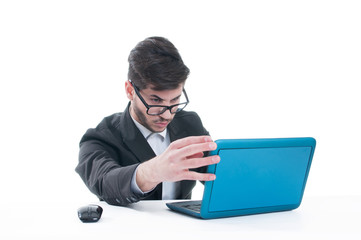 Young business man looking at his laptop with disappointment