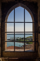Beautiful view on Lake Garda (Italy), Sirmione & Italian Alps through ancient window from Scaliger Castle.